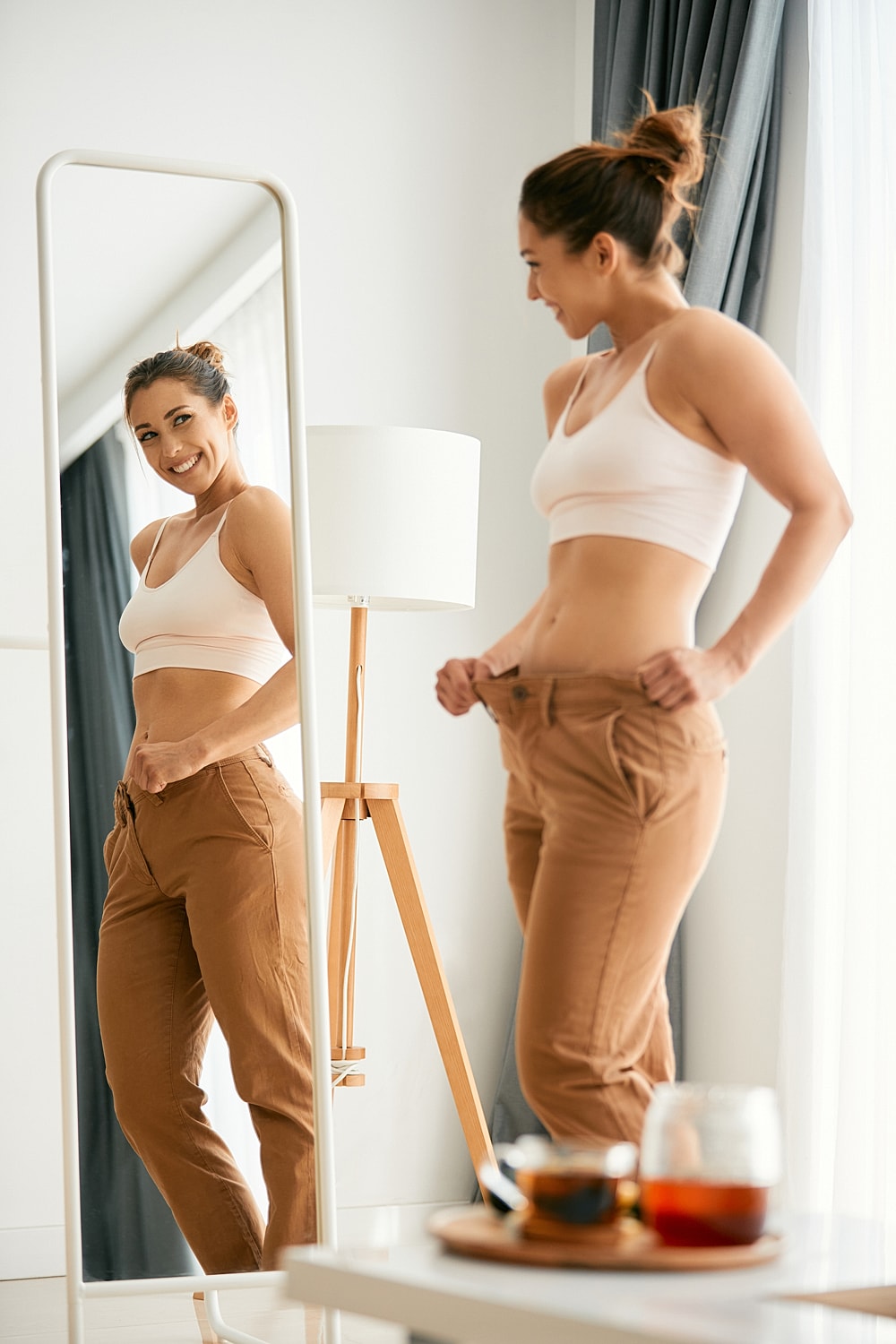 Woman smiling at her reflection in a mirror.