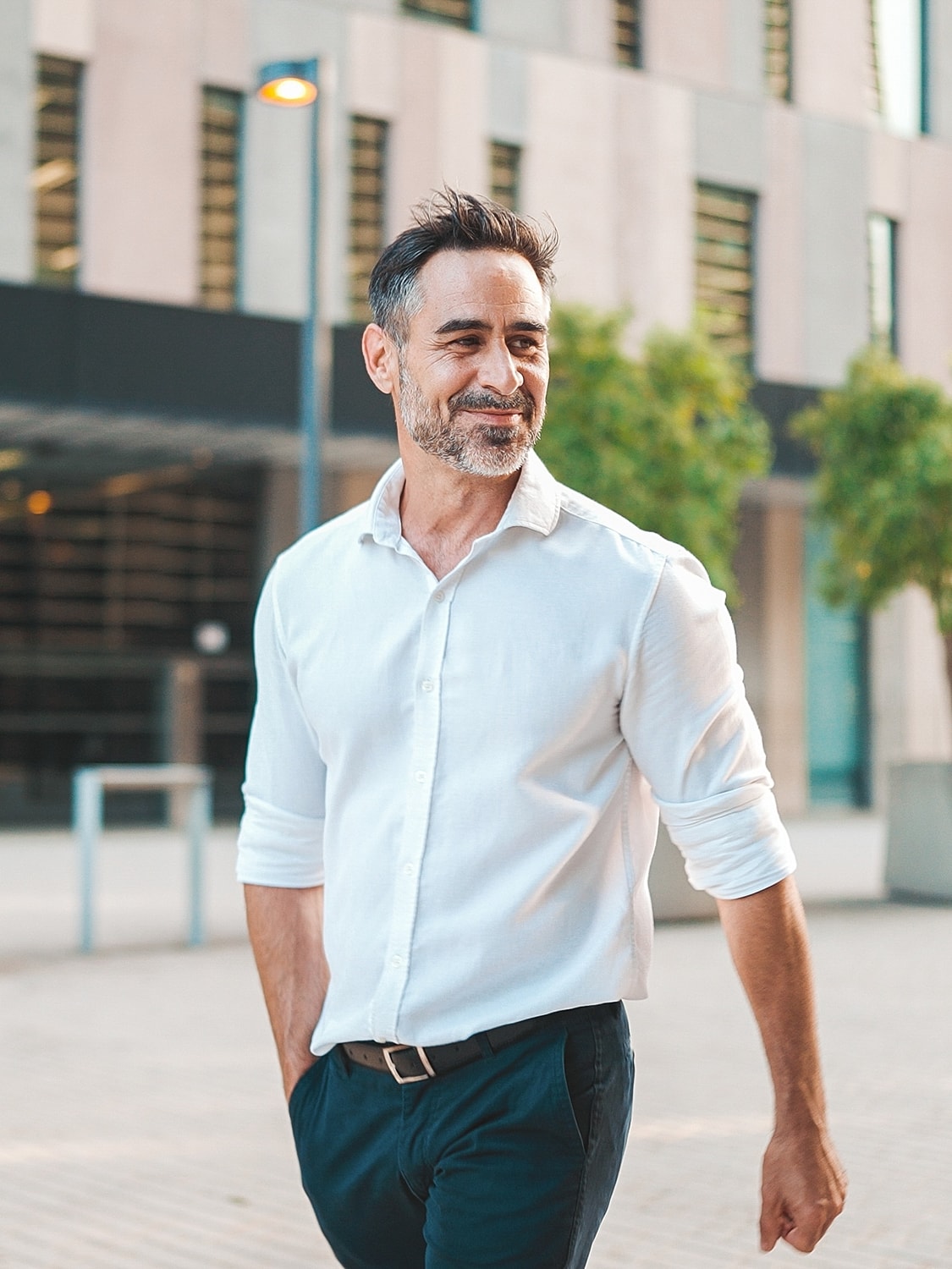 Smiling man walking in urban setting.