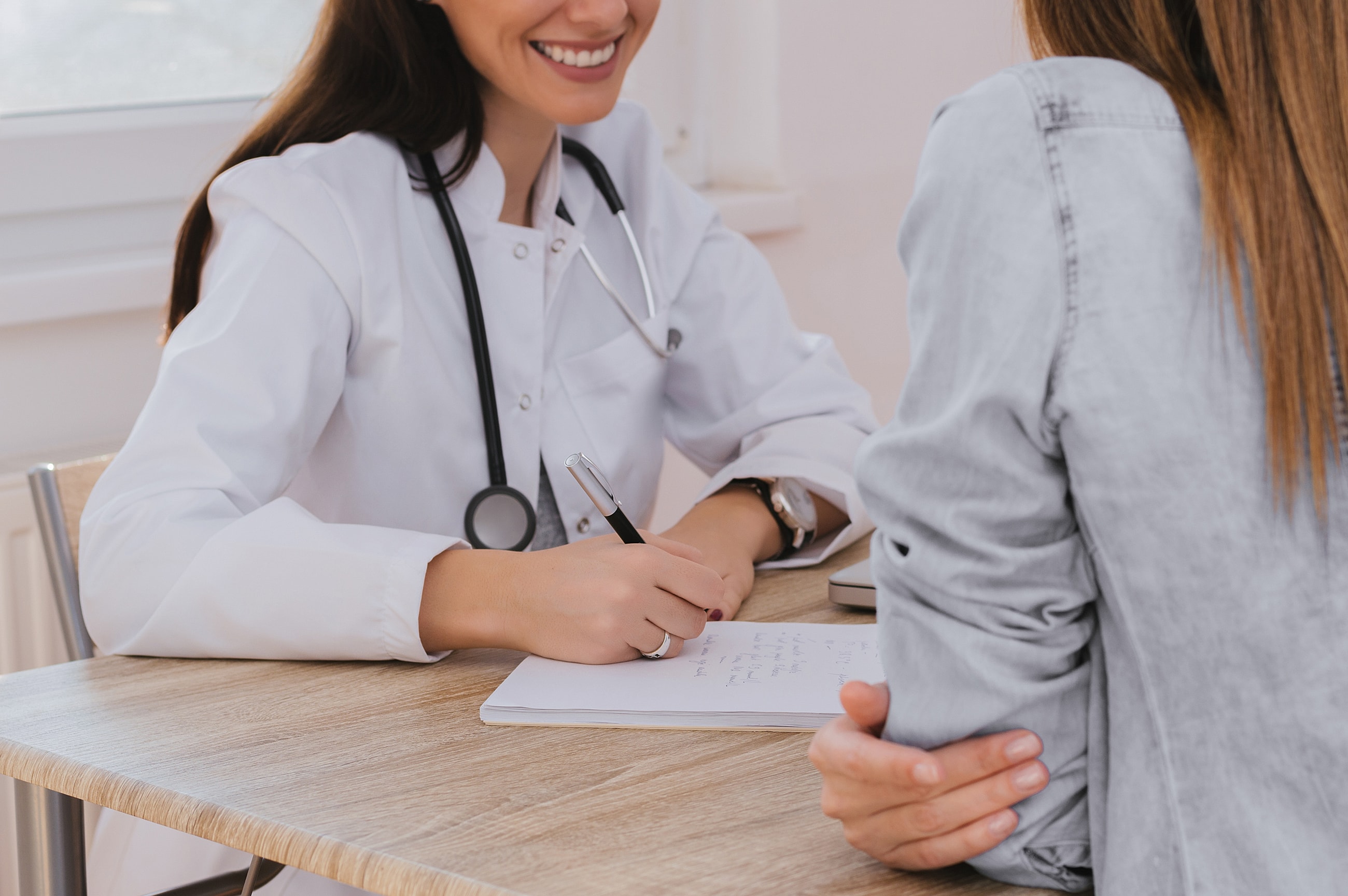 Doctor consulting with patient at a desk.