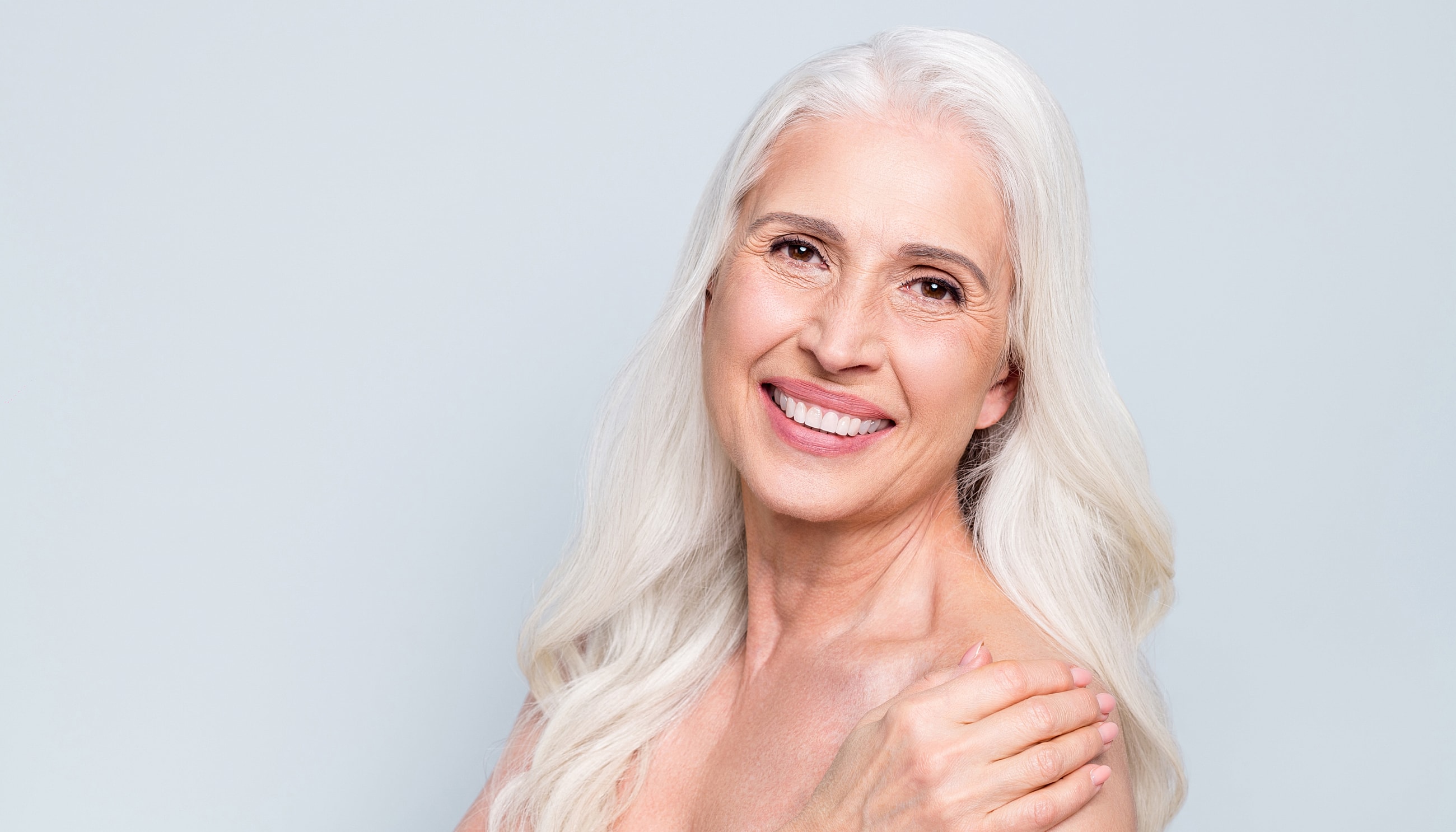 Smiling older woman with long, silver hair.